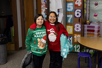 Two students proudly show off their tackiest holiday attire, kicking off Ugly Sweater Day with a splash of festive fashion and fun.